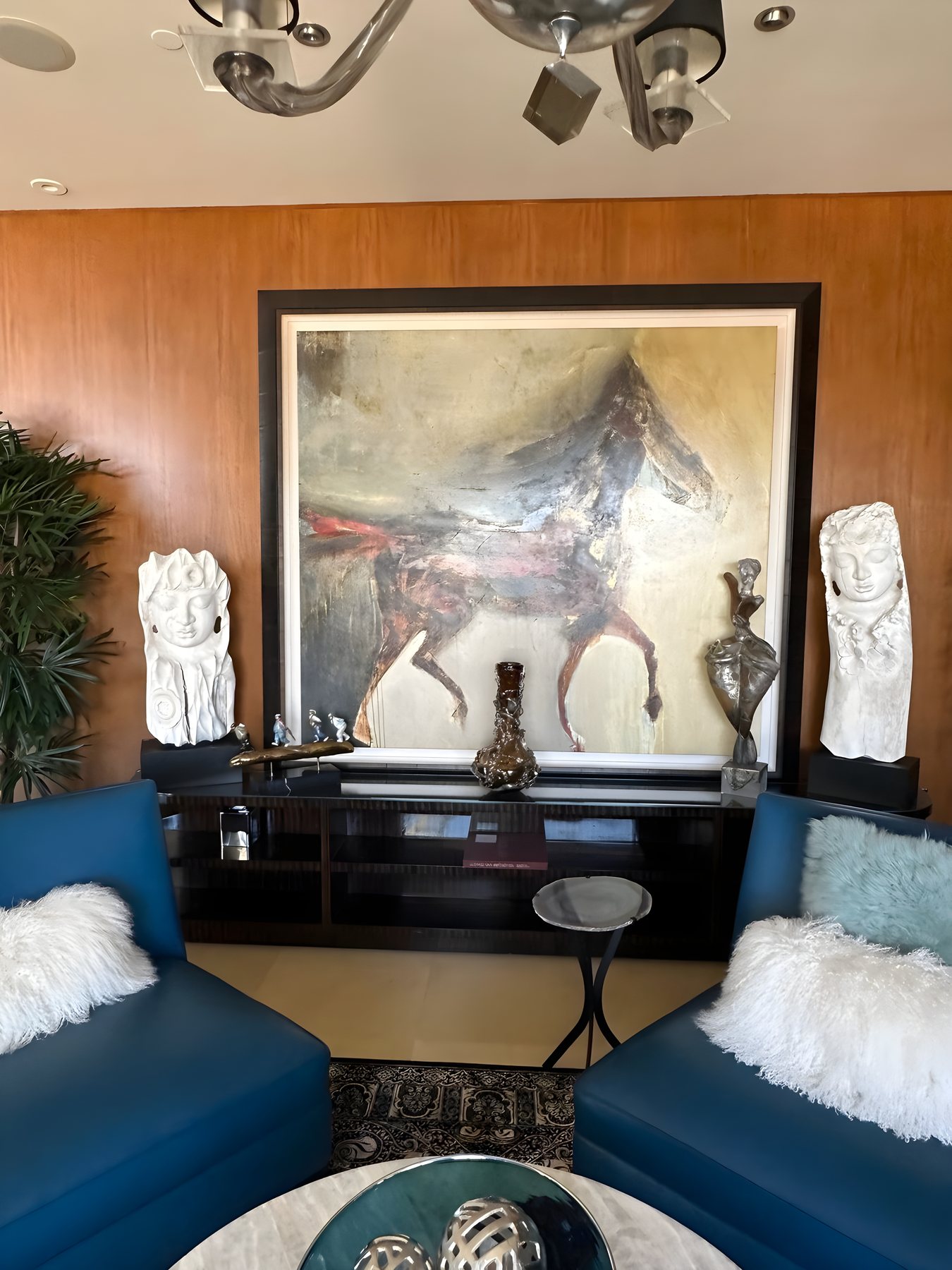 Art deco lounge with blue leather chairs and large equine painting